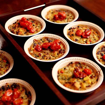 Pasta displayed in multiple bowls, garnished with roasted grape tomatoes